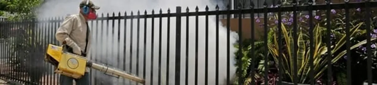 Mosquito control technician fogging a yard perimeter for mosquito reduction in Newark, NJ